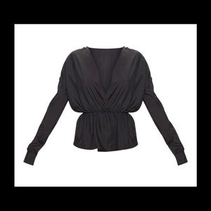 Featuring a black woven material with an elasticated waistband and long sleeves.